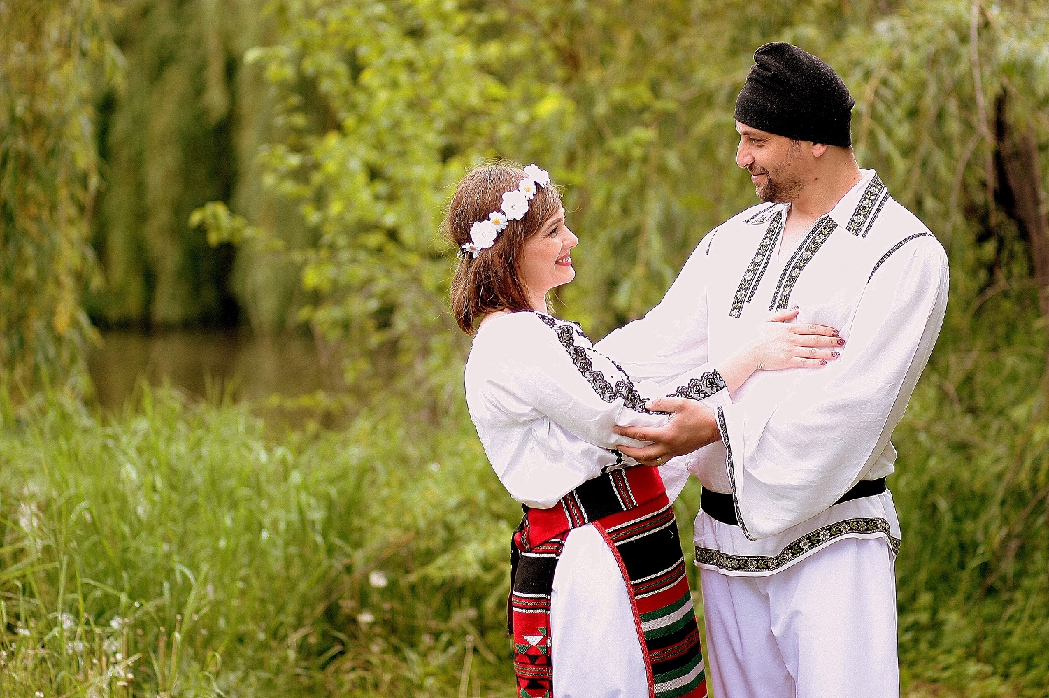 A picture of a couple dressed in traditional Romanian clothing.